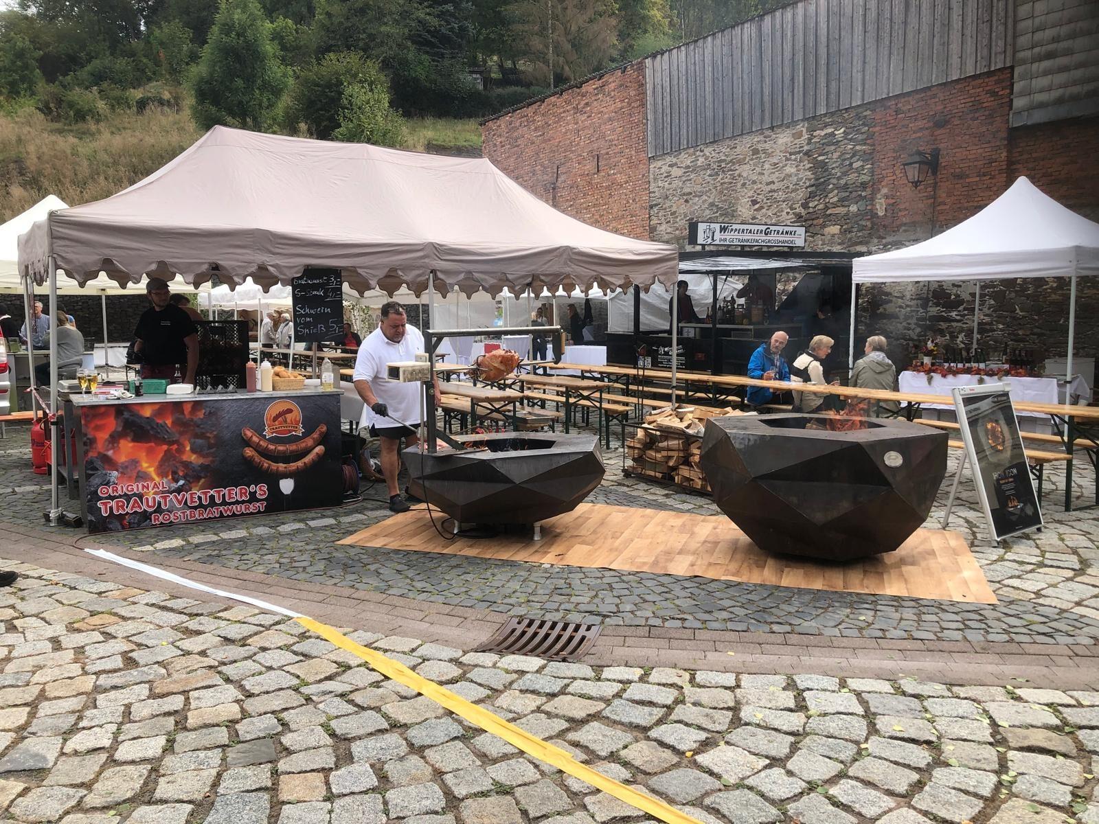 Two Iron Icon fire bowls in use at an event on a cobbled courtyard