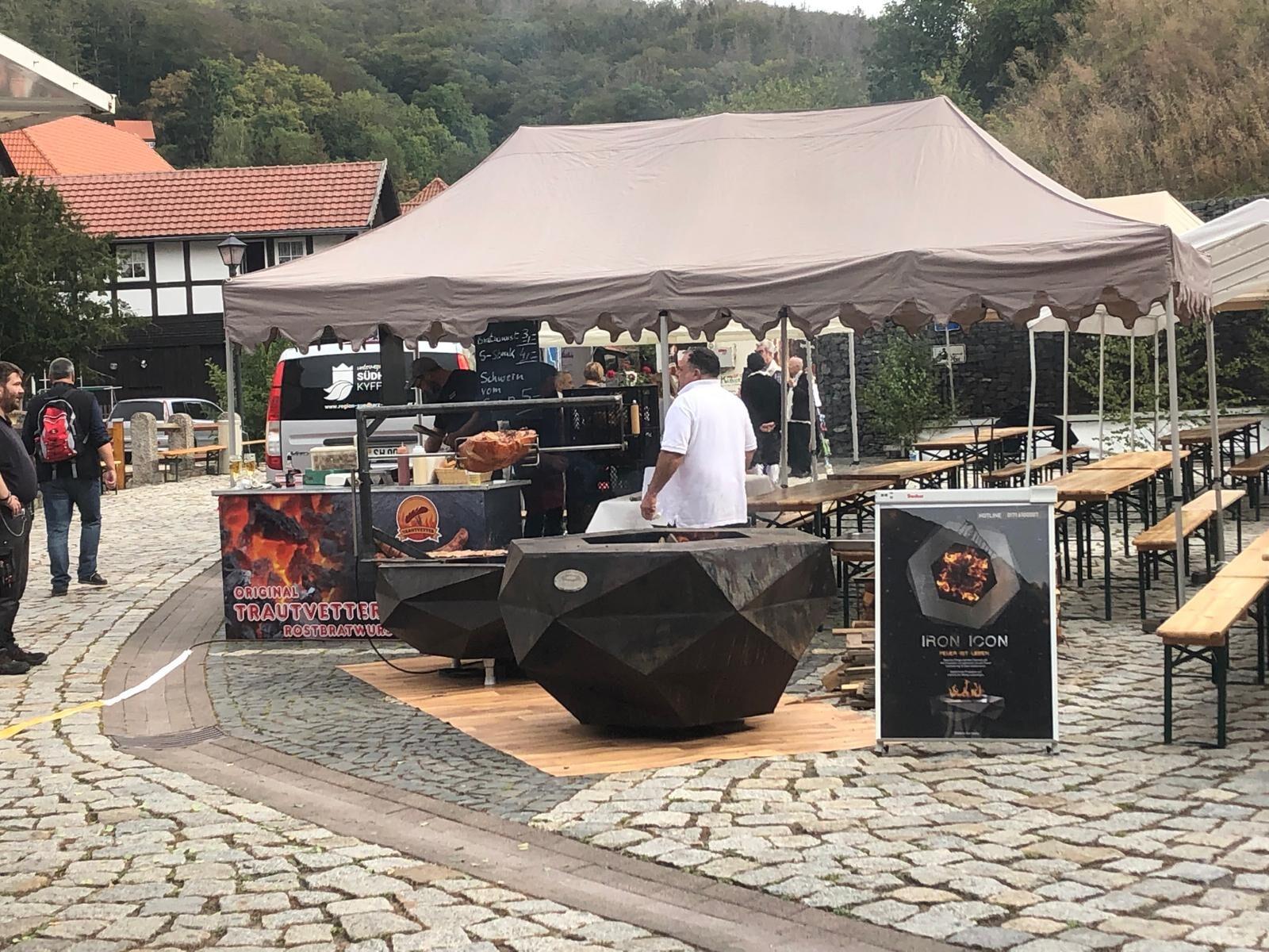 A cook preparing food on an Iron Icon fire bowl at a market event