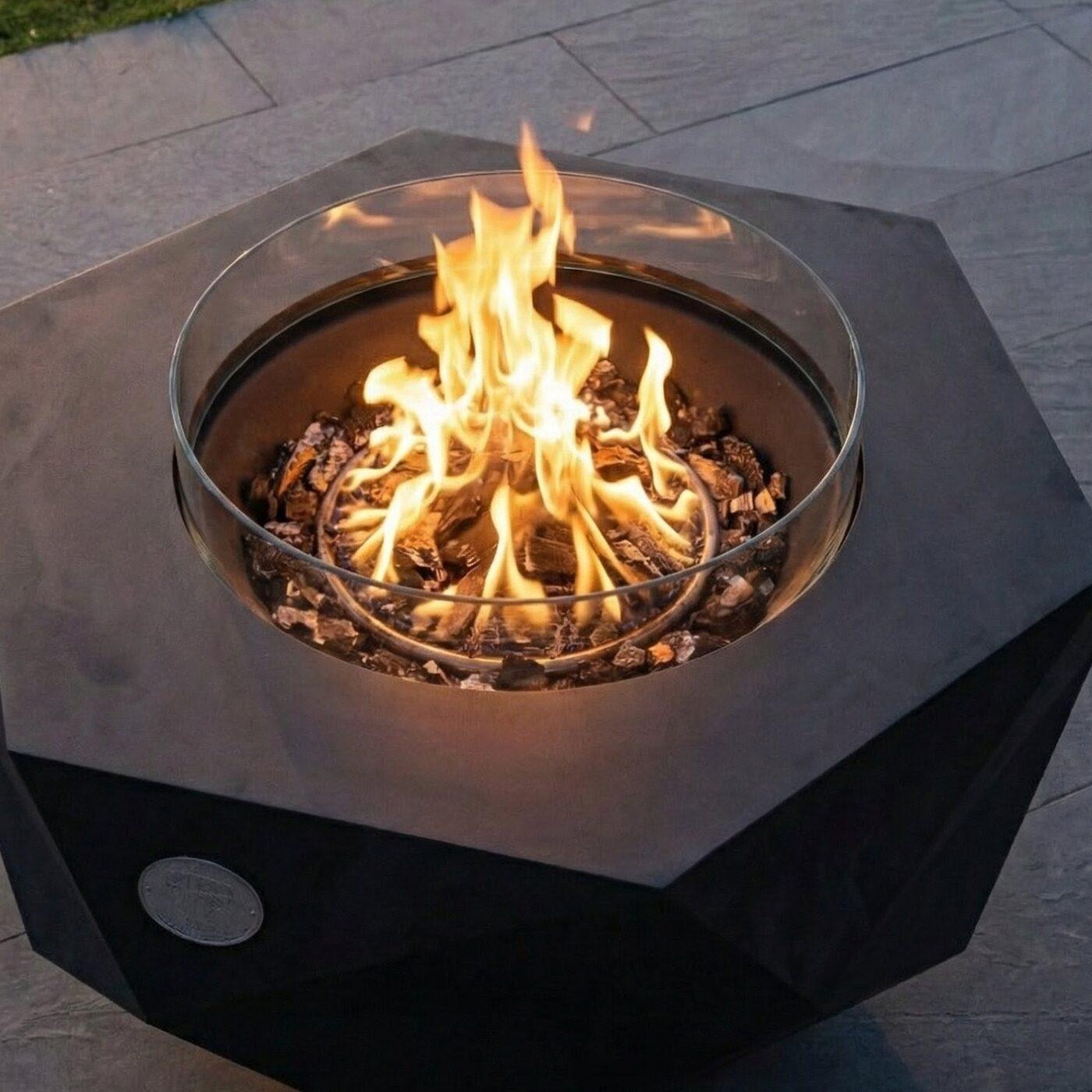 Open flame inside the fire bowl, enclosed by the round glass wind guard